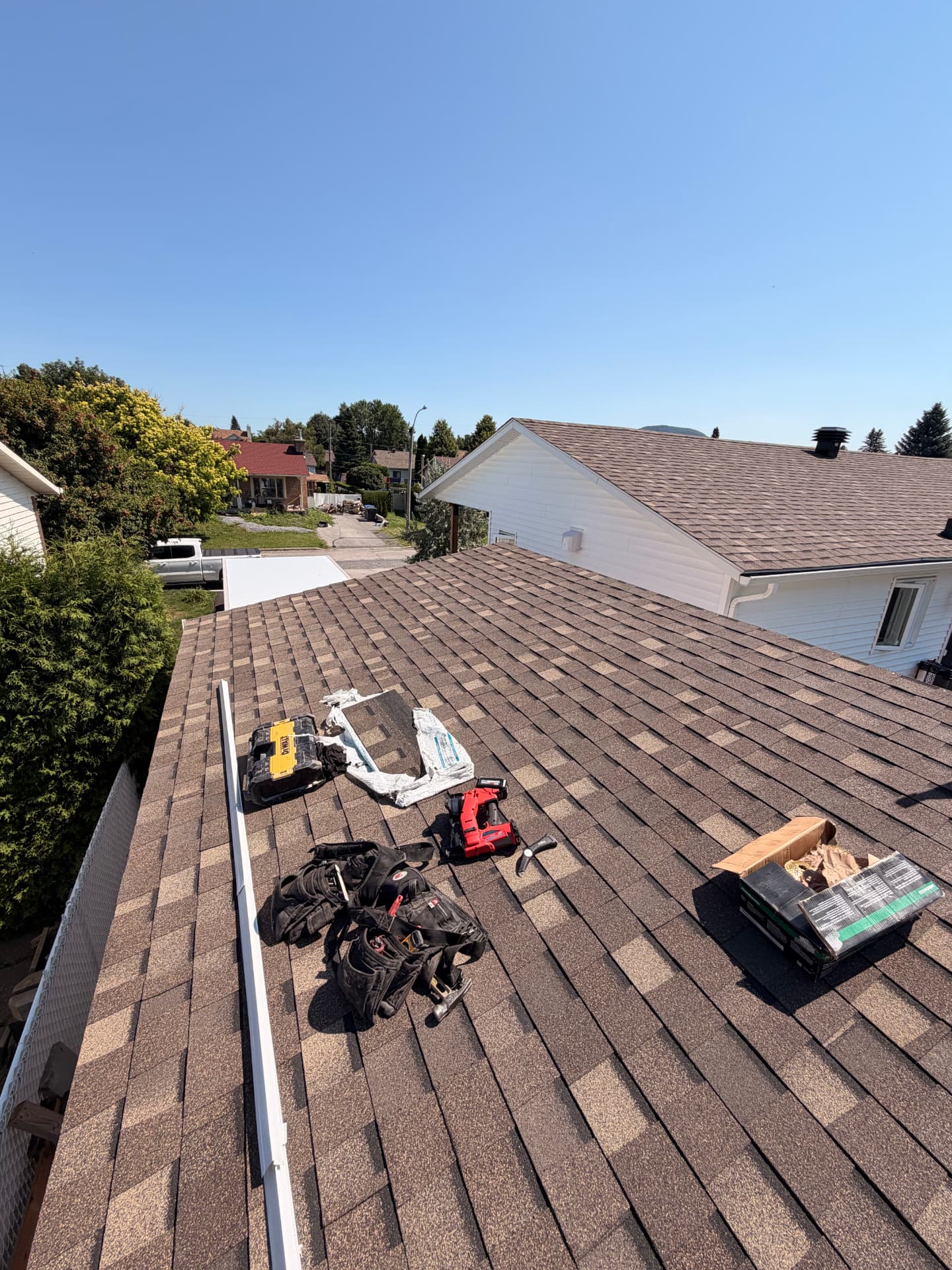 Chantier de toiture résidentielle avec bardeaux, outils et matériaux